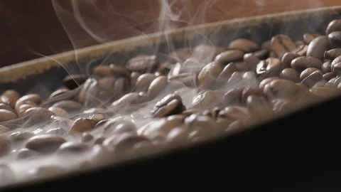 Coffee beans rotate while roasting. Smoke comes from coffee beans. Stock Footage 121229998