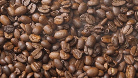 Coffee beans rotate while roasting. Smoke comes from coffee beans. Stock Footage 121230061