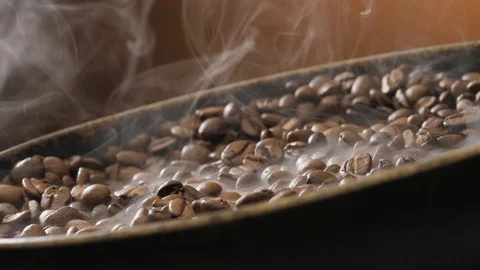 Coffee beans rotate while roasting. Smoke comes from coffee beans. Stock Footage 121540174