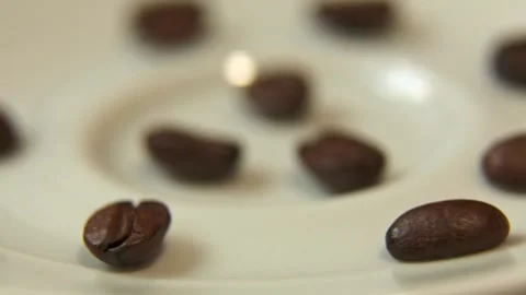 Coffee beans rotating slightly on plate with shifting focus Video stock 323154198