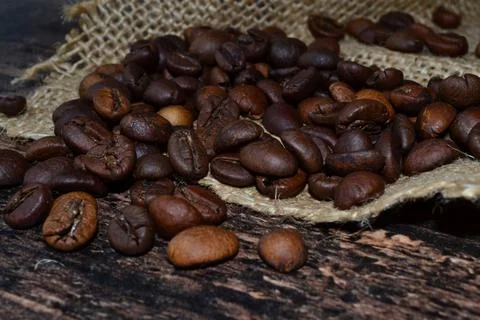 Coffee beans scattered on burlap Stock Photos