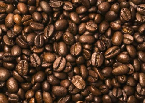 Coffee beans scattered over the surface 3 Stock Photos