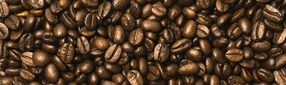 Coffee beans scattered over the surface Stock Photos