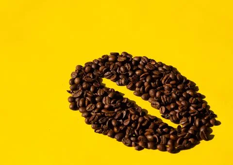 Coffee beans in the shape of a bean with a yellow background Stock Photos