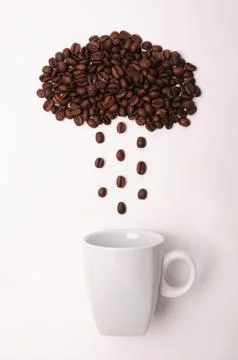 Coffee beans in shape of cloud pouring rain in a white cup on white background Stock Photos