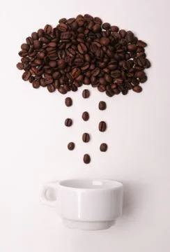 Coffee beans in shape of cloud pouring rain in a white cup on white background Foto stock