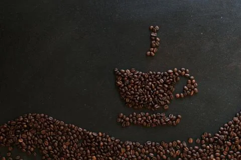 Coffee beans in the shape of a cup on dark background Stock Photos