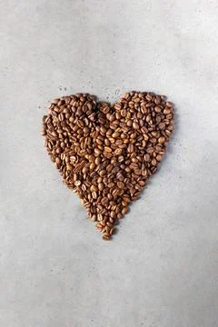 Coffee beans in the shape of a heart on a gray background. Stock-Fotos