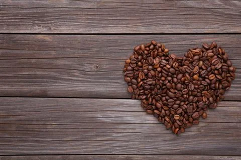 Coffee beans in shape of heart on grey background Stock Photos
