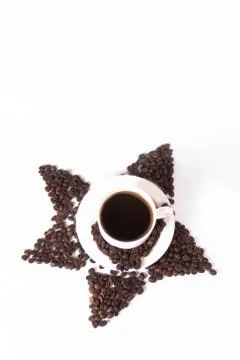 Coffee beans in the shape of a star with a cup. Top view with copyspace for y Stock Photos