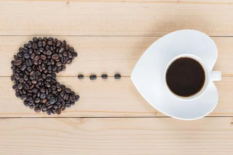Coffee beans shaped to fish head eating coffee bean and coffee cup Stock Photos