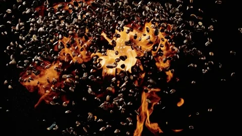 The coffee beans shoot into the air with fire below it Stock Footage 253406629