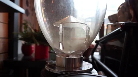 Coffee beans slowly falling into empty professional coffee grinder Stockbeeldmateriaal 84835942