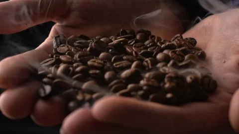 Coffee beans with smoke in man's hand in slow motion Video stock 114918124