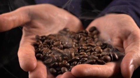 Coffee beans with smoke in man's hand in slow motion 스톡 동영상 115477032
