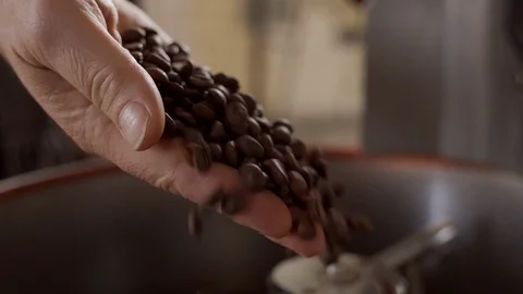 Coffee beans spill out of a man's hand. Slow motion. Roasting coffee. Stock Footage 116495465