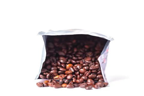 Coffee beans spilling out of packaging on a white background. Stock Photos