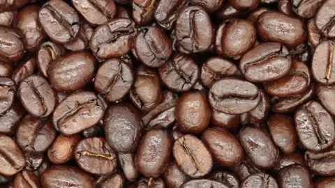 The coffee beans spin and rotate, top view. Stock Footage 228457045