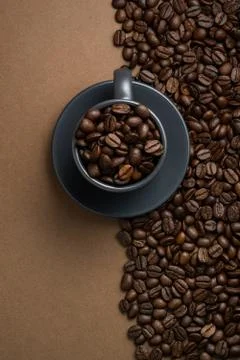 Coffee beans split the frame into two parts and a cup filled with coffee bean Foto stock