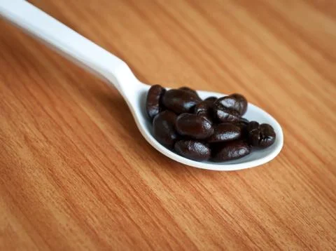 Coffee beans in a spoon . Stock Photos