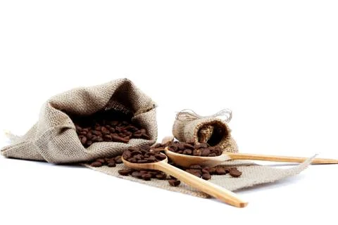 Coffee beans in a spoons on sacking. Stock Photos