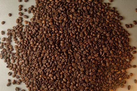 Coffee beans spread across a surface waiting to be brewed into a delicious drink Stock Photos
