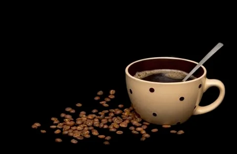 Coffee beans spread around coffee mugs on a black background Stock Photos