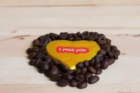 Coffee beans surrounded Chocolate wrapper on Valentine's Day, Wood background Stock Photos