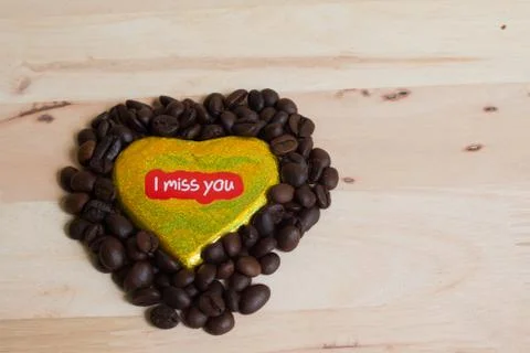 Coffee beans surrounded Chocolate wrapper on Valentine's Day, Wood background Stock Photos