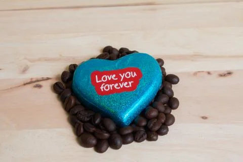 Coffee beans surrounded Chocolate wrapper on Valentine's Day, Wood background Stock Photos