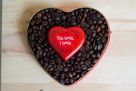 Coffee beans surrounded Chocolate wrapper on Valentine's Day, Wood background Stock Photos