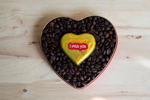 Coffee beans surrounded Chocolate wrapper on Valentine's Day, Wood background Stock Photos