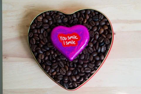 Coffee beans surrounded Chocolate wrapper on Valentine's Day, Wood background Stock-Fotos