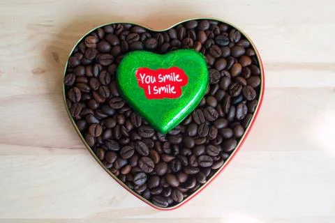 Coffee beans surrounded Chocolate wrapper on Valentine's Day, Wood background Foto stock