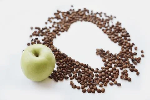 Coffee beans in tooth shape and green apple Stock Photos