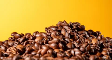 Coffee beans on vibrant orange gradient background with copy space for text Stock Photos