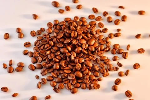 Coffee beans on the white background with side warm light, top view Stock Photos
