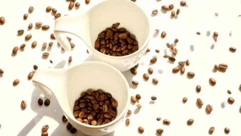 Coffee beans in white ceramic cups and falling coffee beans. Stock Footage 171901920