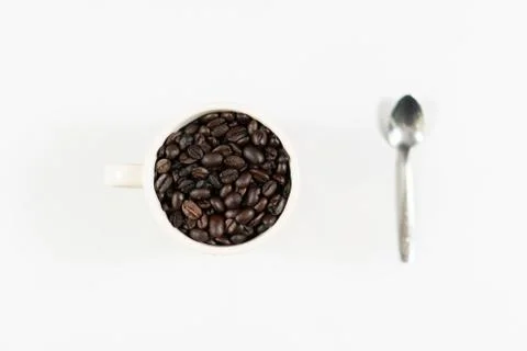 Coffee beans in white cup and spoon with white background Stock Photos