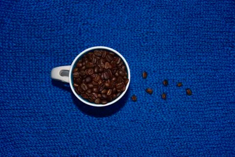 Coffee beans in the white cup on the blue background Stock Photos