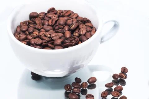 Coffee beans in white cup on mirror Foto stock