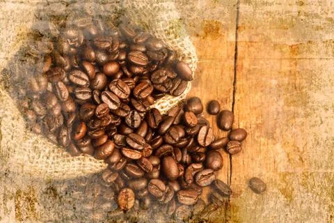 Coffee beans on wood table on old wall textured background. retro filter. Stock Photos