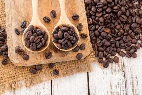 Coffee beans in wooden spoon on wooden background Stock Photos