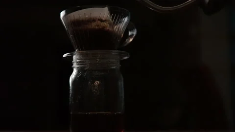 Coffee being brewed into a clear glass pot. A Dripping stream ripples and fil Stock Footage 131588575