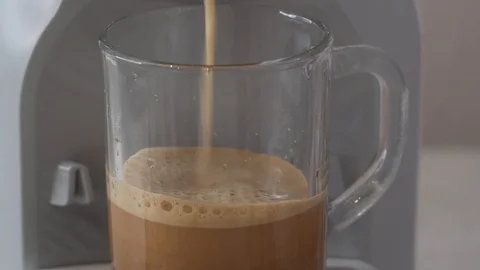 Coffee being made with capsule coffee machine in transparent cup Stock Footage 104493421