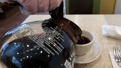 Coffee, black being poured in cup at diner by waitress. Stock Footage 127399072