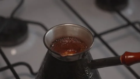 Coffee boiling in copper cezve on gas stove Stock Footage 327288367