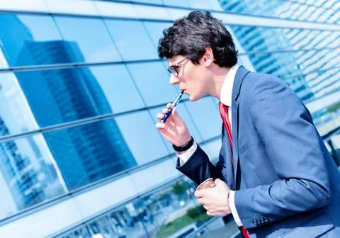 Coffee break with an electronic cigarette Stock Photos