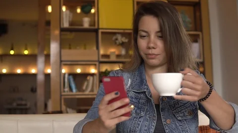 Coffee break. Female using mobile phone while drinking coffee Stock Footage 88683689