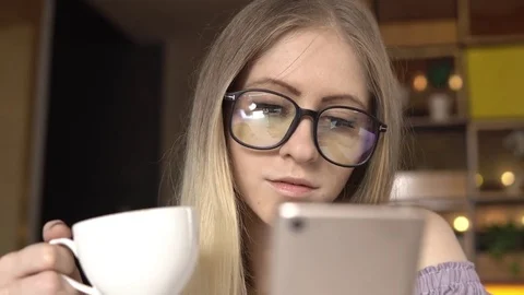 Coffee break. Female using smartphone while drinking coffee Stock Footage 84090782
